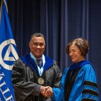 Provost Mili shakes hands with man